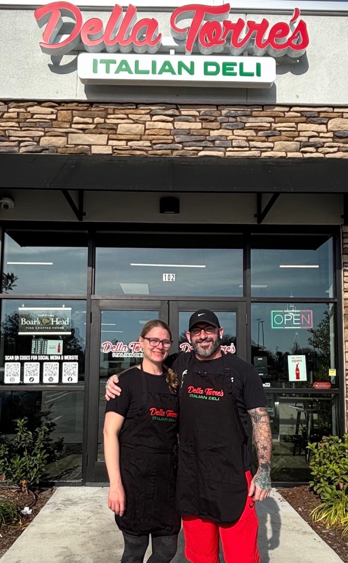 Hal and Jennifer, founders of Della Torre&rsquo;s Italian Deli, standing in front of the shop in St. Augustine